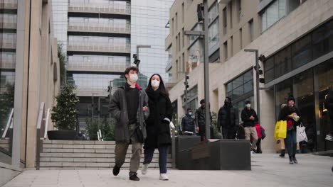 Gente-Enmascarada-Caminando-Por-Las-Calles-De-Tiendas-Y-Rascacielos-En-El-Centro-De-Milán-Durante-Un-Día-Nublado-De-Invierno