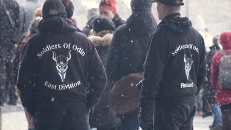 Medium-wide-shot-of-a-couple-of-people-at-the-Helsinki-protests,-wearing-Soldiers-of-Odin-jumpers