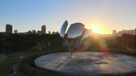 Orbit-of-Floralis-Generica-steel-sculpture-in-Naciones-Unidas-square-at-sunset-with-sun-flares-behind-Recoleta-buildings
