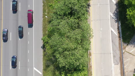 A-top-down-view,-directly-over-a-parkway-median-with-green-trees-and-grass