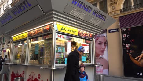 Typical-Viennese-sausage-stand-with-people-walking-past