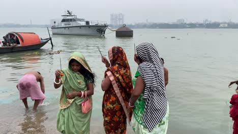 Toma-Estática-De-Las-Mujeres-Indias-Haciendo-Chatt-Puja-De-Pie-Dentro-Del-Agua-Del-Río-Ganges-Al-Amanecer-En-Kolkata,-Bengala-Occidental,-India