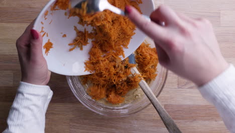 Hands-Adding-Grated-Carrots-with-Tablespoon-into-Carrot-Cake-Dough