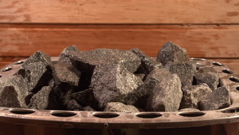 Closeup-shot-showing-a-pile-of-sauna-hot-stones-with-water-being-poured-on