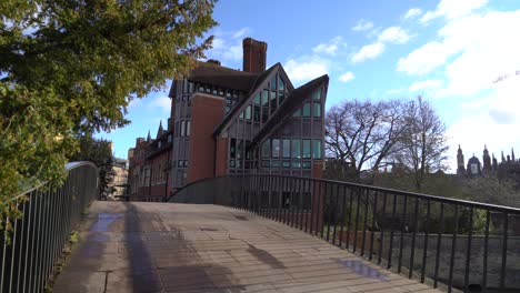 People-walking-cycle-across-the-Garret-Hostel-Bridge-next-to-Kings-College-University-in-Cambridge,-UK