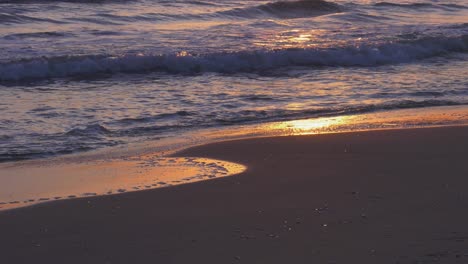 Sonnenaufgang-Am-Strand,-Meereswellen,-Die-Im-Morgengrauen-Auf-Das-Sandige-Ufer-Rollen,-Zeitlupe,-Mittelmeerküste,-Spanien