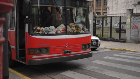 Parked-bus-with-stuffed-animals-inside,-man-with-dog-crossing-street