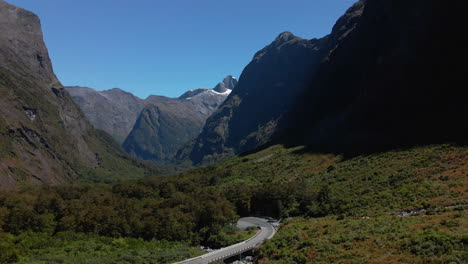 Mountain-road-ascending-up-a-narrow-valley-in-Fiordland-Southland,-New-Zealand