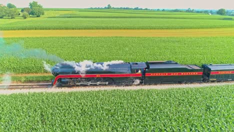 Aerial-Landscape-of-Farmlands-and-a-Antique-Steam-Engine-Blowing-Lots-of-Smoke-Passes-Backing-Up-Thru-the-Corn-Fields-and-Running-Parallel-on-an-Early-Summer-Morning