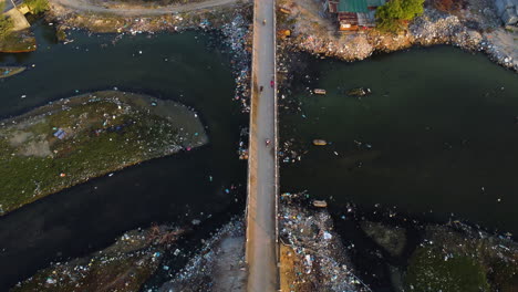 Aerial-birdseye-static-shot-of-bridge-over-polluted-river,-Vietnam