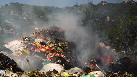 Close-up-shot-of-rubbish-heap-burning-outdoors-at-asian-landfill-during-sunlight---Air-Pollution-and-Contamination