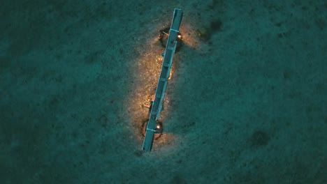 Breathtaking-aerial-drone-flight-bird's-eye-view-drone-shot-of-a-swing-with-lights-in-water-on-a-dream-beach-Gili-Trawangan-Bali-Lombok-a-small-island-at-blue-hour-after-sunset-by-Philipp-Marnitz