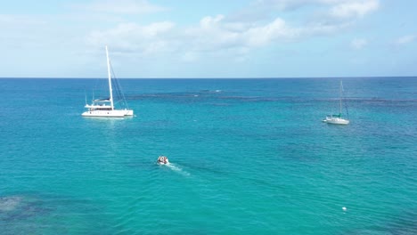 Motorboot-Transportiert-Menschen-Zum-Katamaran-Für-Einen-Ausflug-Auf-Dem-Karibischen-Meer-An-Einem-Sonnigen-Tag-Mit-Blauem-Wasser-Und-Himmel---Dominikanische-Republik,-Playa-Punta-Popy