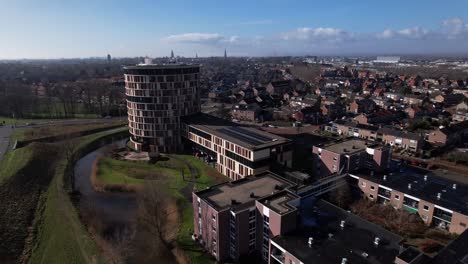 Town-view-with-residential-neighbourhood-and-colorful-round-towering-building-of-service-flat-elderly-residential-home-in-Dutch-tower-town