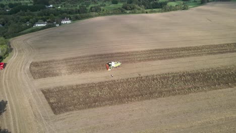 Drone-shot-of-a-combine-harvester-at-work-in-a-large-field