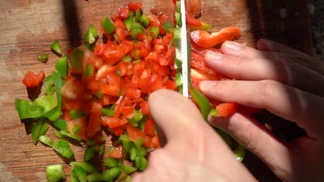 Cook-Slicing-Red-And-Green-Bell-Peppers-In-Small-Cubes