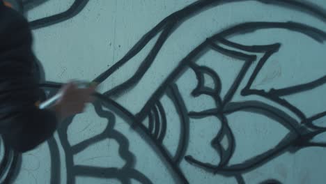 Graffiti-artist-shaking-spray-paint-can-preparing-to-paint-wall
