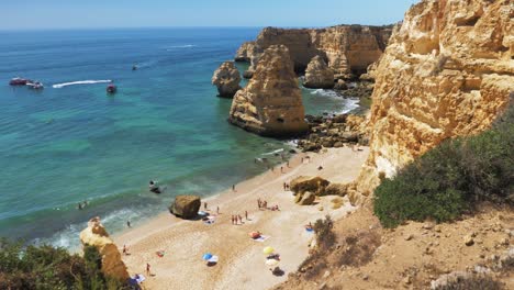 Slowmotion-Wideshot-of-Marinha-Beach-Portugal-During-Sunny-Weather-with-Small-Amount-of-Tourists-Sunbathing