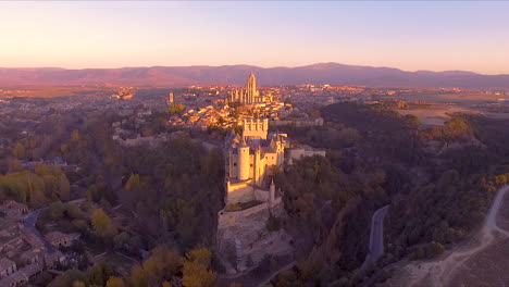 Luftaufnahme-Von-Segovia-Alcazar-Und-Der-Stadt-Im-Herbst-Mit-Wunderschönen-Baumfarben-Und-Sonnenuntergang