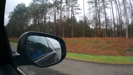 Driving-along-a-highway-and-through-a-forest---hyper-lapse-of-the-passenger-point-of-view-out-the-window-with-a-view-the-rear-view-mirror