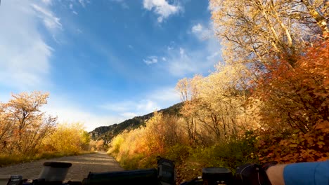 Riding-a-four-wheeler-vehicle-along-a-mountain-road-in-autumn---first-person-view