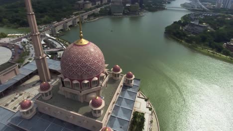Drone-circling-over-the-beautiful-Putra-Mosque-in-Putrajaya,-Malaysia