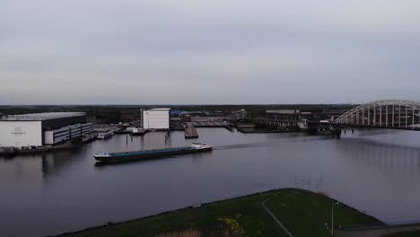 Entladenes-Frachtkahnschiff,-Das-Auf-Dem-Fluss-Noord-Mit-Flussufergebäuden-In-Den-Niederlanden-Segelt