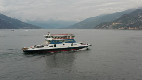 Aerial-of-ferry-driving-over-Lake-Como-towards-a-distant-town-in-Italy