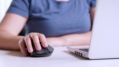 Woman's-hand-holds-mouse-for-computer-and-controls-it,-office-concept
