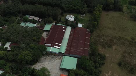 Luftaufnahme-Eines-Fabrikgebäudes-In-Cu-Chi,-Vietnam-Mit-Bauernhöfen-Und-Wäldern-An-Einem-Sonnigen-Tag-Mit-Blauem-Himmel