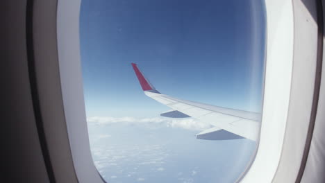 Airplane-wing-seen-through-window-while-flying