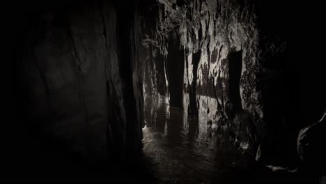 Cueva-Oscura-Junto-Al-Océano-Con-Luz-Que-Atraviesa-El-Final-Del-Túnel