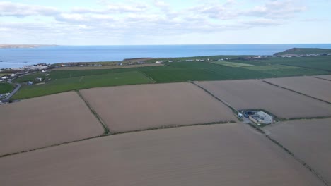 A-coastal-farm-land-with-the-view-over-Atlantic-and-sandy-beach,-an-aerial-footage