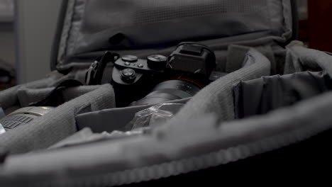 Nahaufnahme-Der-Hände-Eines-Fotografen,-Der-Sein-Objektiv-Und-Seine-Kameraausrüstung-In-Seine-Tasche-Packt,-Um-Sich-Auf-Ein-Bevorstehendes-Shooting-Vorzubereiten