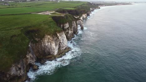 Aerial-view-of-the-rugged-coastline-looking-towards-Portrush-with-Magheracross-Viewpoint-in-the-foreground,-County-Antrim,-Northern-Ireland