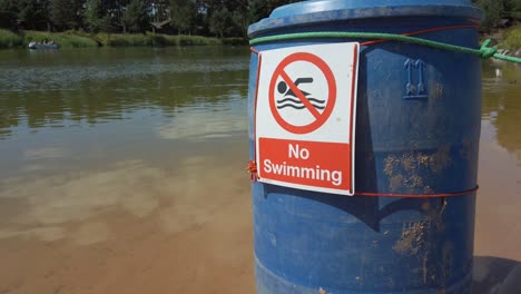 No-Swimming-warning-sign-on-lakeside-waters-edge