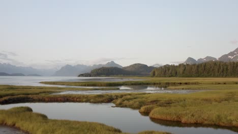 Drone-Flying-Over-Estuary-With-Scenic-View-Of-Mountain-Landscape-In-Alaska