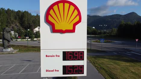 Shell-gas-station-in-Norway---closeup-ascending-aerial-of-billboard-roadsign-with-price-information-and-company-logo