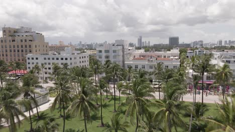 Luftaufnahmen-über-Dem-Sonnigen-Palmenpark-Zeigen-Miami-City-In-Wolken