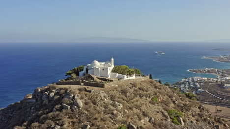 Paros-Greece-Aerial-v7-drone-fly-around-hilltop-st-antonios-monastery-with-beautiful-white-church-facade-overlooking-at-breathtaking-landscape-and-aegean-seascape---September-2021