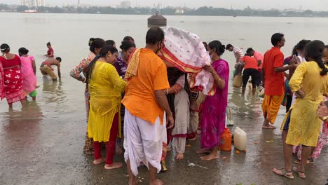 La-Gente-Está-Tomando-Kola-Bou-Para-Bañarse-En-El-Río-Ganges,-Que-Es-El-Ritual-Más-Popular-De-Durga-Puja