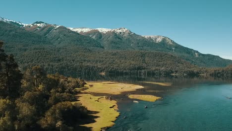Drohne-Bewegt-Sich-über-Dem-Fluss,-Um-Die-Herbstlandschaft-Mit-Dem-See-Im-Hintergrund-Zu-Sehen