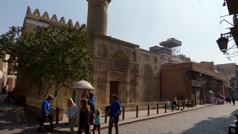 People-walking-along-Masjid-Al-Aqmar,-Aqmar-Mosque-in-Cairo,-Egypt