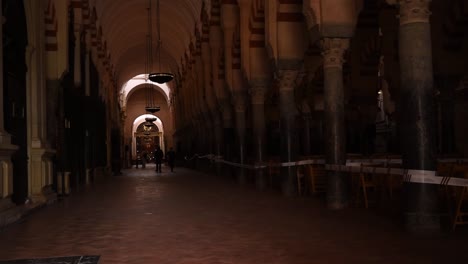 Long-an-dark-alley-of-arches-in-former-mosque-now-cathedral,-Córdoba,-Cordoba,-Spain