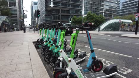 Row-Of-Dockless-Electric-Scooters-Parked-On-Upper-Bank-Street-Outside-Canary-Wharf-Station-Entrance