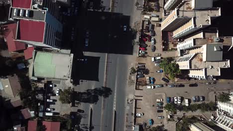 Amazing-aerial-look-down-view-over-roof-tops-of-high-buildings-to-car-road-traffic-in-largest-city-in-Ethiopia,-Africa