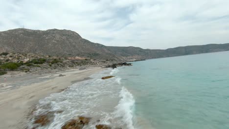FPV-over-Kedrodasos-beach-near-Elafonissi-beach-on-Crete-island-with-azure-clear-water,-Greece,-Europe