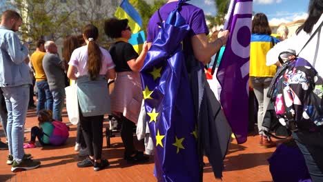 Zeitlupenschwenk-über-Einen-Mann,-Der-Während-Der-Antikriegsproteste-Die-EU-Flagge-Auf-Dem-Rücken-Trägt