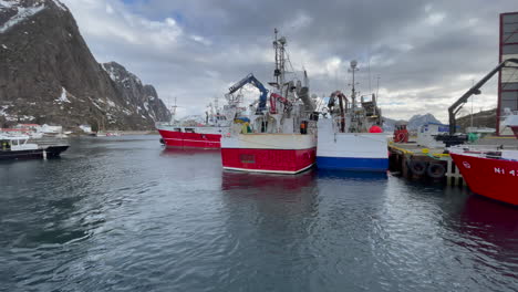 Panning-shot-of-Norwegian-fishing-Vessels-on-the-pier-of-a-dock-for-Service-in-Svolvaer,-Lofoten-Island