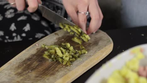 Woman-with-sharp-knife-chop-pickle-into-small-cubes-on-wooden-board